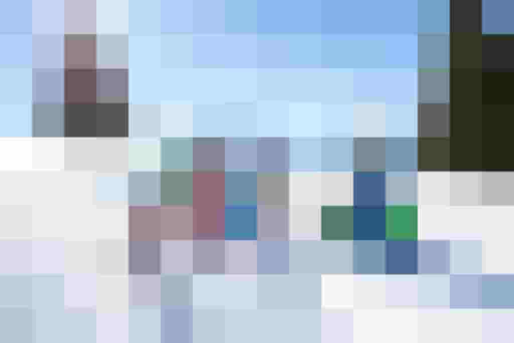 Familie spielt und lacht im Schnee mit Bergkulisse im Hintergrund. Winterfreude erleben!