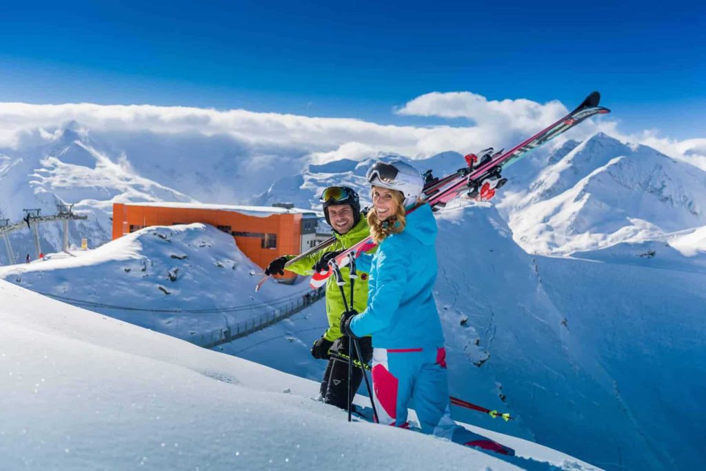 Paar mit Skiern in Winterlandschaft, genießen die Berge in der Aktivregion Gastein.
