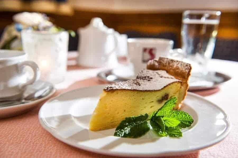 Köstlicher Kuchen auf einem Teller, dekoriert mit frischer Minze und serviert mit Tassen.