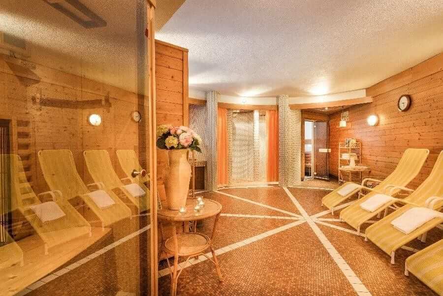 Wellnessbereich im Hotel Steindlwirt mit Liegen, Uhr und entspannender Atmosphäre.