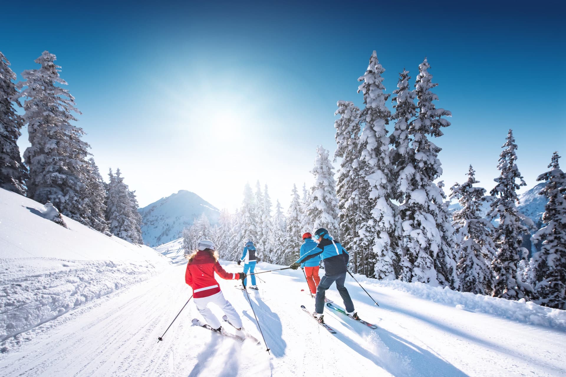 Skifahrer genießen eine sonnige Abfahrt im schneebedeckten Gasteinertal.