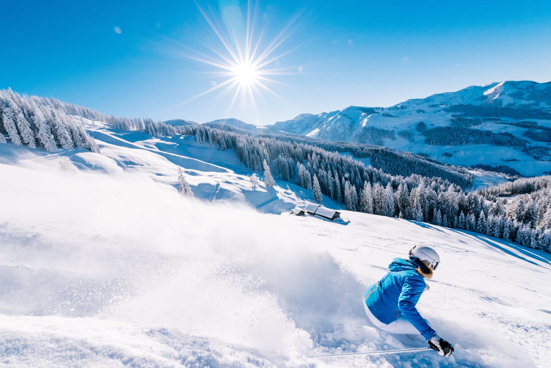 Skifahrer in unberührtem Schnee vor sonnigem Bergpanorama in Dorfgastein.