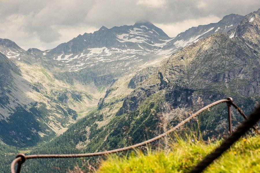 Uitzicht op alpine berglandschap met sneeuwvelden en wolken