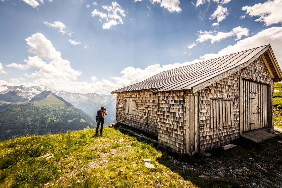 Wandelaars voor een houten hut in de Alpen