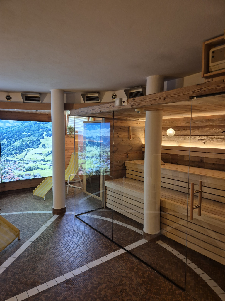 Holzsauna mit Glasfront und Liegestühlen im Wellnessbereich