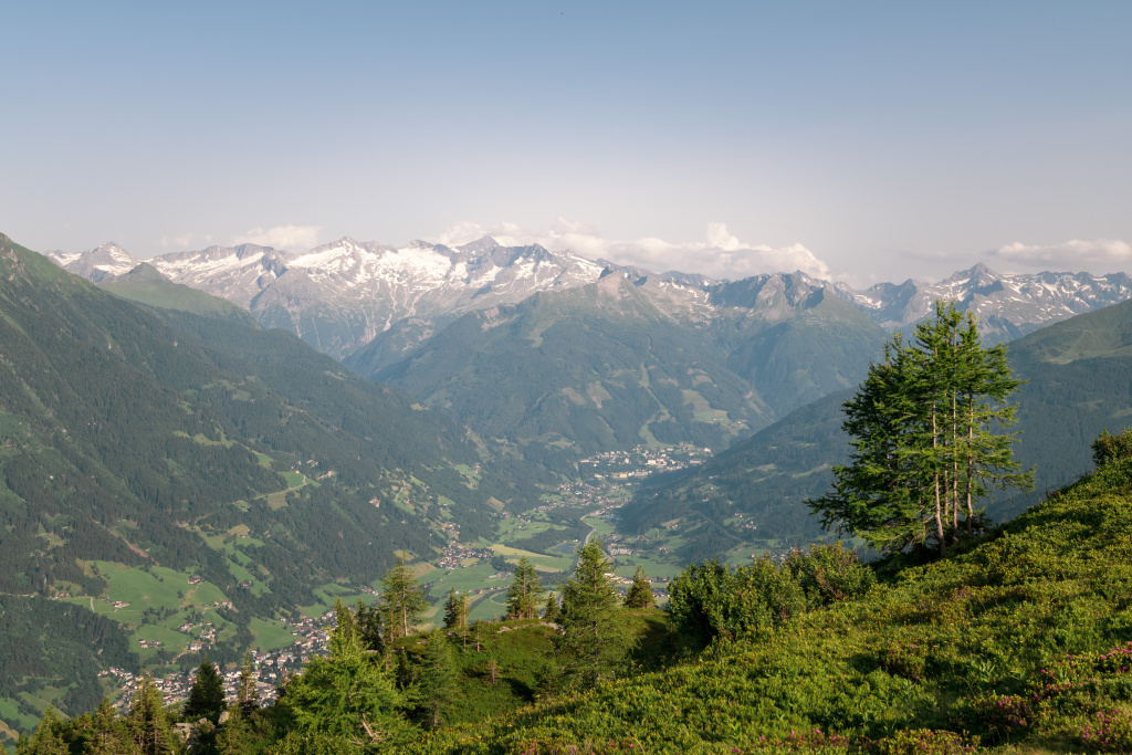 Gasteinertal von der Biberalm mit grünen Hängen, Talorten und schneebedeckten Gipfeln